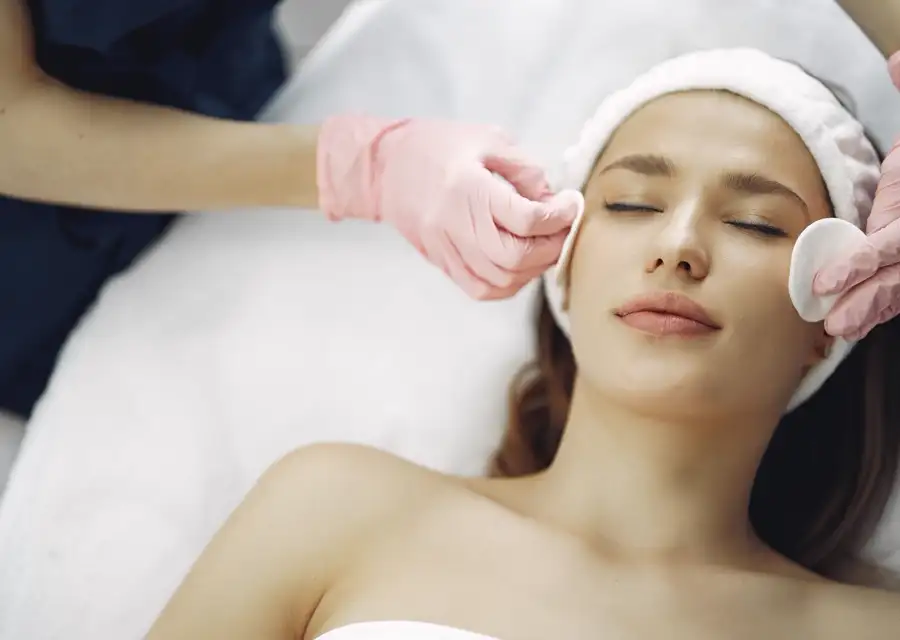 Esteticista aplicando un tratamiento facial a una clienta