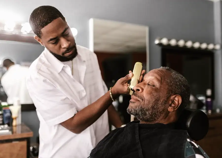 Barbero cortando el pelo a un cliente en una barbería